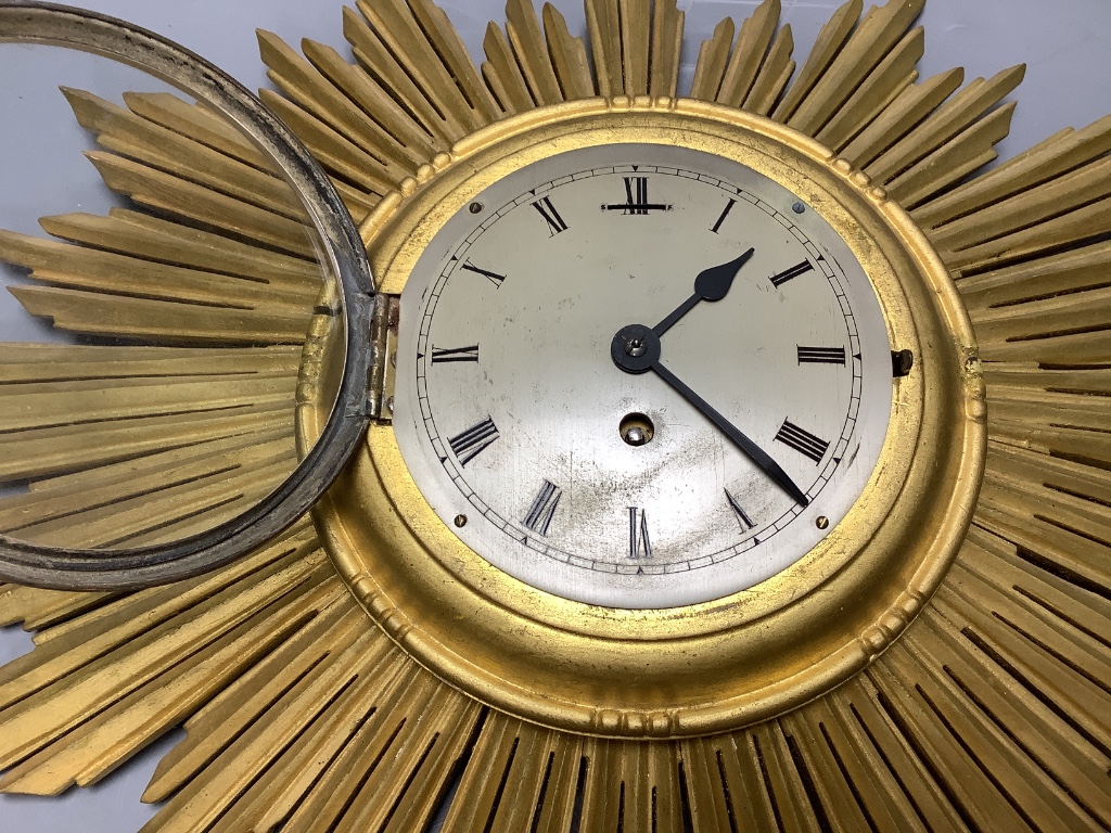 A giltwood sunburst wall clock, length 60cm